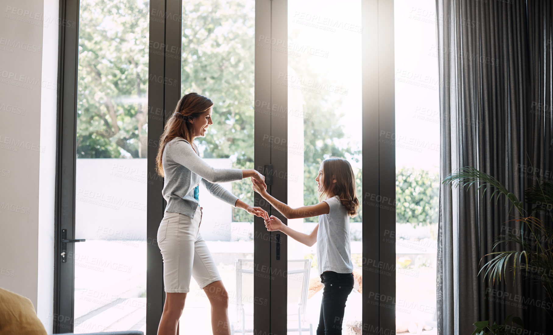Buy stock photo Cropped shot of an attractive young woman and her daughter dancing while spending time together at home