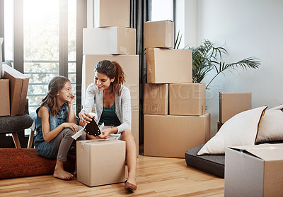 Buy stock photo Full length shot of an attractive young woman and her daughter moving into a new house