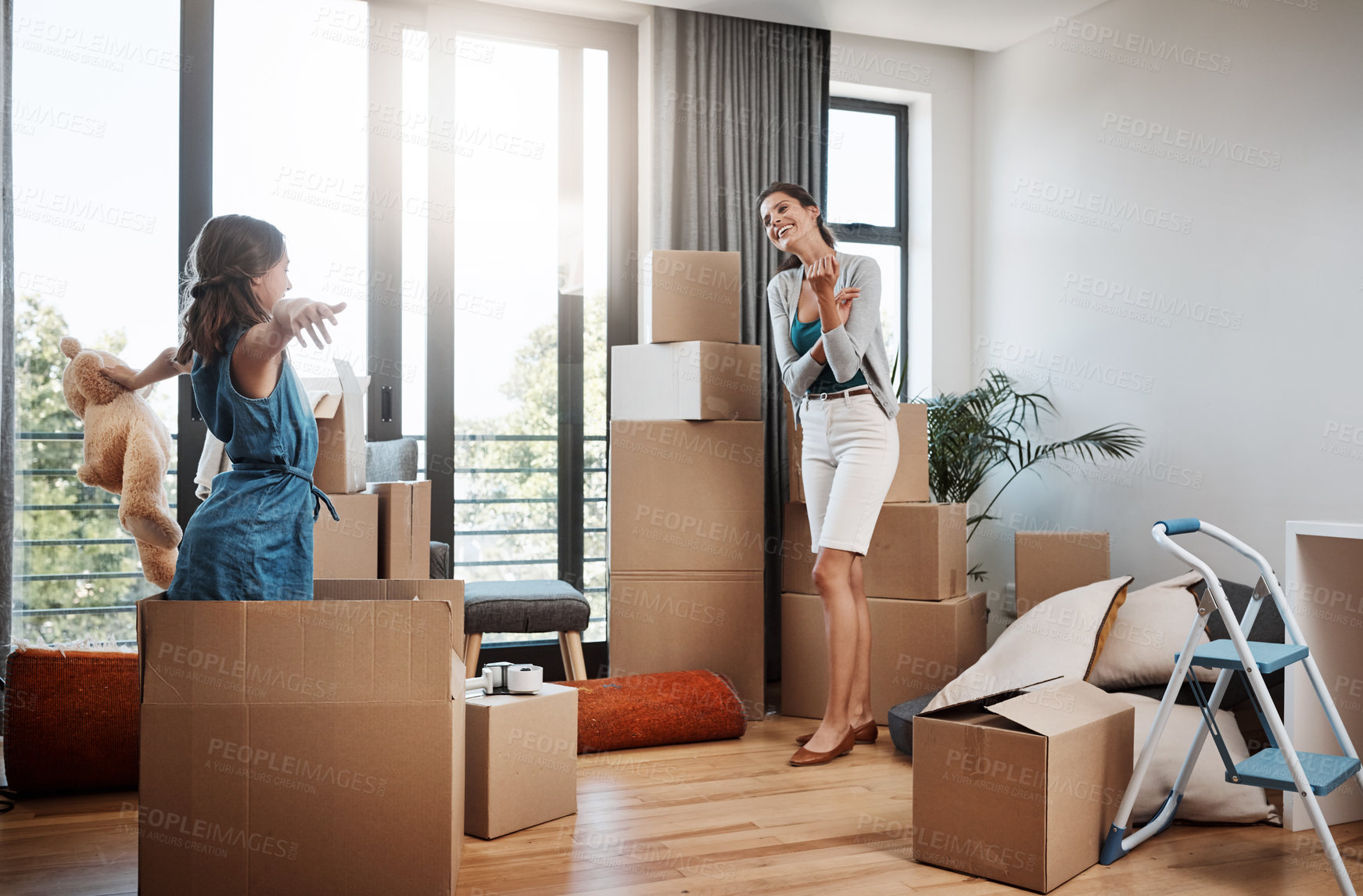 Buy stock photo Full length shot of an attractive young woman and her daughter moving into a new house