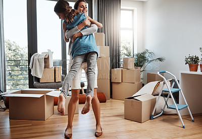 Buy stock photo Full length shot of an attractive young woman and her daughter dancing while moving into their new home