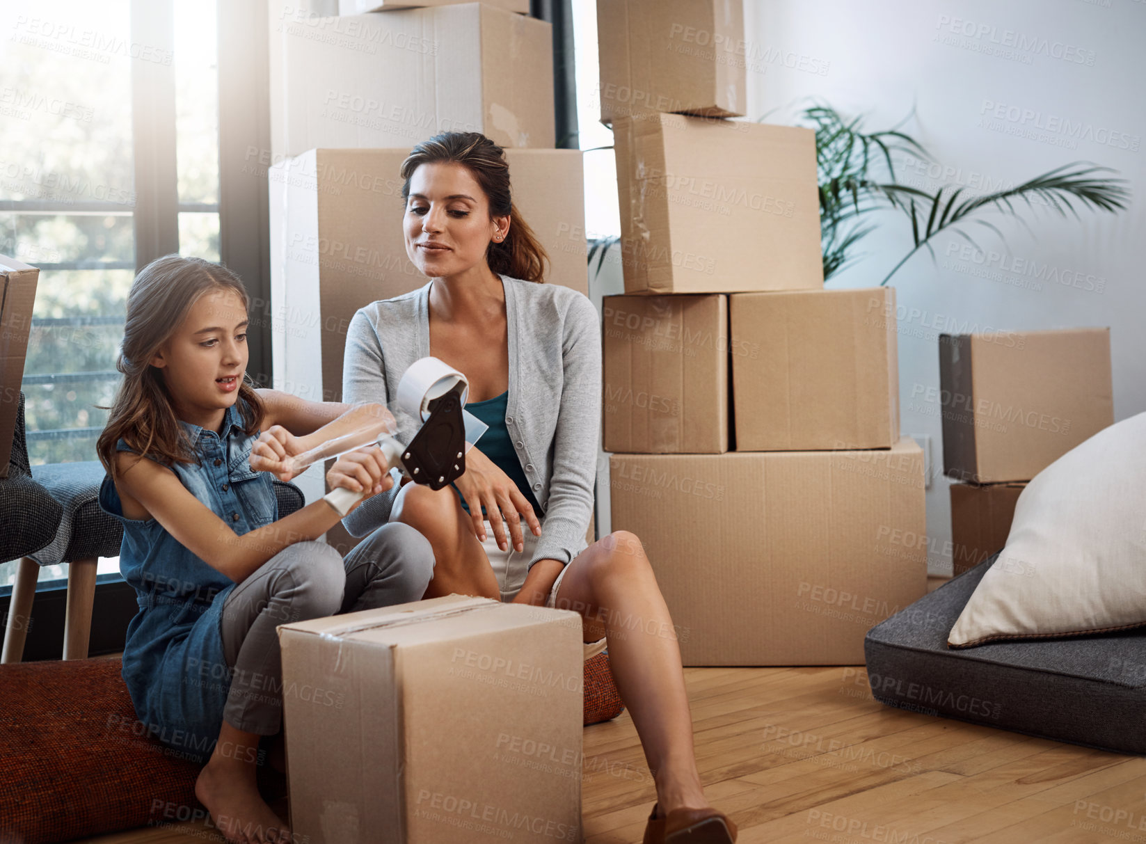 Buy stock photo Full length shot of an attractive young woman and her daughter moving into a new house