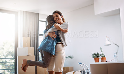 Buy stock photo Cropped shot of an attractive young woman and her daughter dancing while moving into their new home