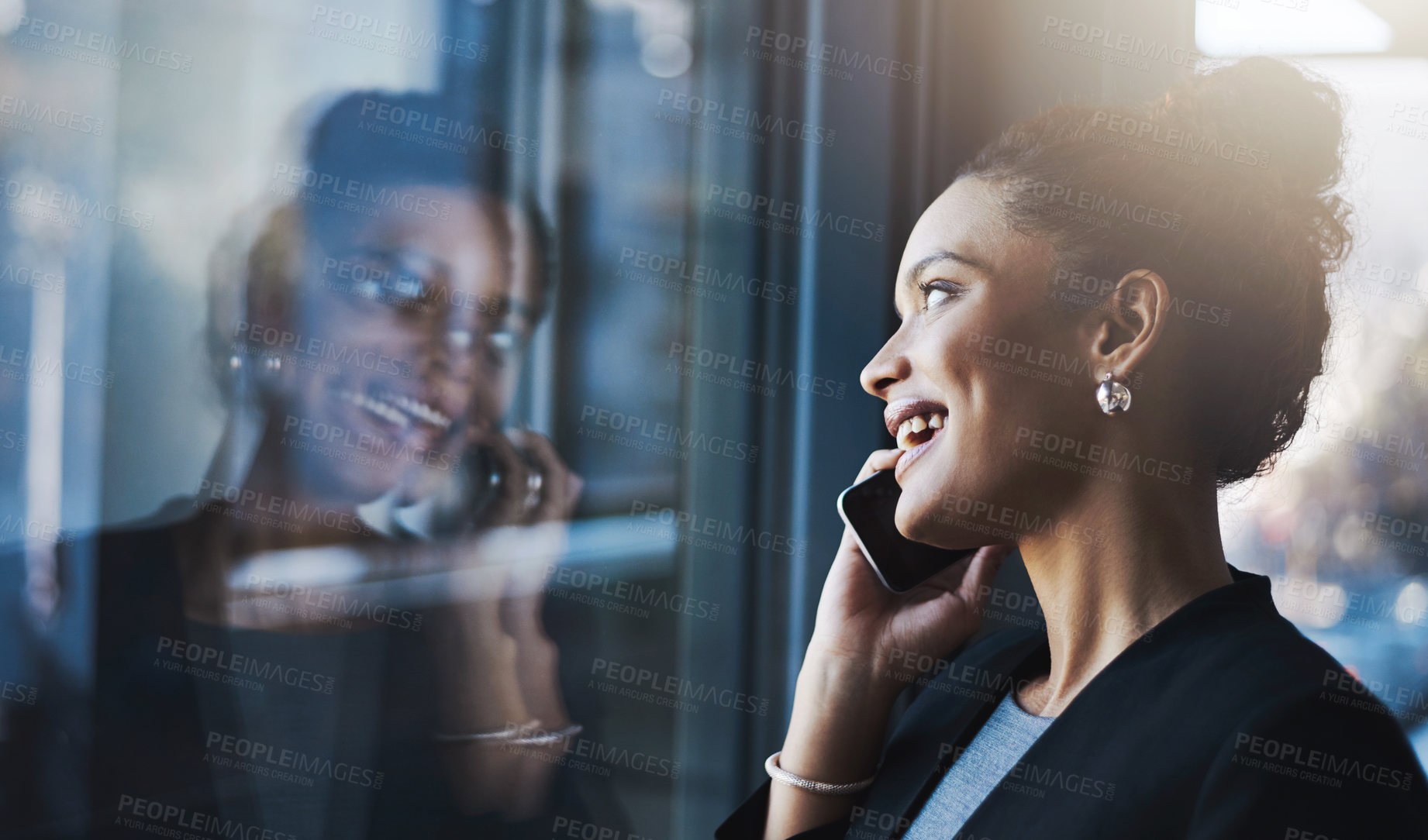 Buy stock photo Shot of a young businesswoman talking on a cellphone in an office