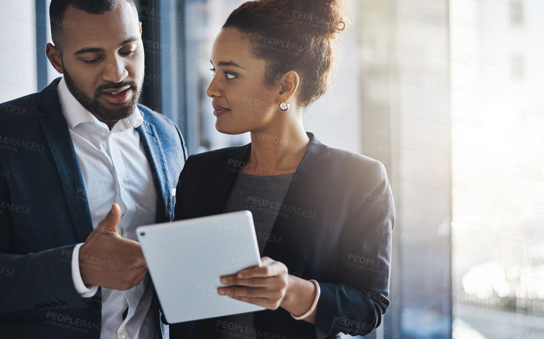 Buy stock photo Shot of two businesspeople working together on a digital tablet in an office