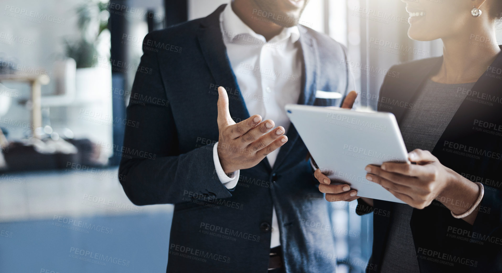 Buy stock photo Closeup shot of two unrecognizable businesspeople using a digital tablet together in an office
