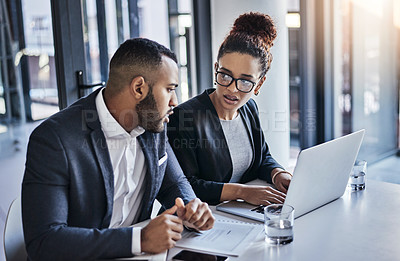 Buy stock photo Shot of two businesspeople working together on a laptop in an office