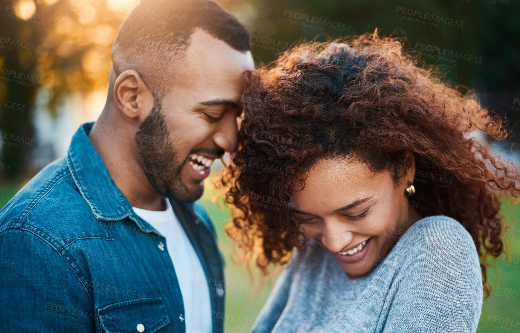 Buy stock photo Happy, love and couple in park laugh together for bonding, relationship and communication. Dating, lens flare and man with woman in nature, garden and outdoors for trust, romance and relax on weekend