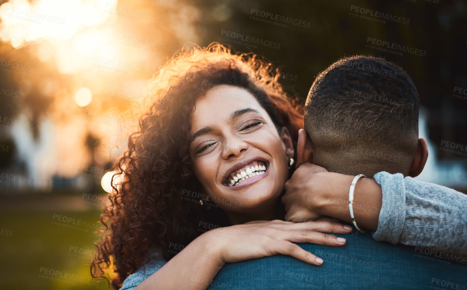 Buy stock photo Portrait of a young woman hugging her boyfriend outdoors