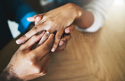 Buy stock photo Cropped shot of a man putting an engagement ring onto his girlfriend's finger