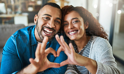 Buy stock photo Shot of a young couple making a heart gesture with their hands outdoors