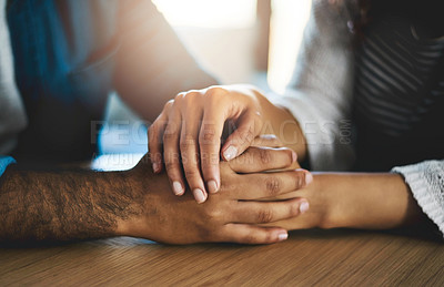 Buy stock photo Cropped shot of a man and woman compassionately holding hands at a table