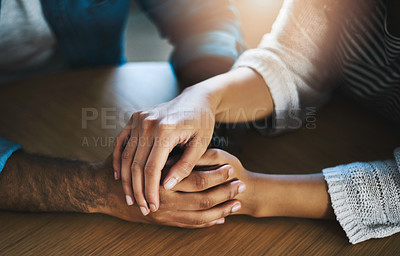 Buy stock photo Cropped shot of a man and woman compassionately holding hands at a table