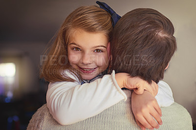 Buy stock photo Cropped portrait of an adorable little girl embracing her dad in their home