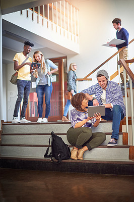 Buy stock photo Shot of a university students using a digital tablet on the staircase at campus