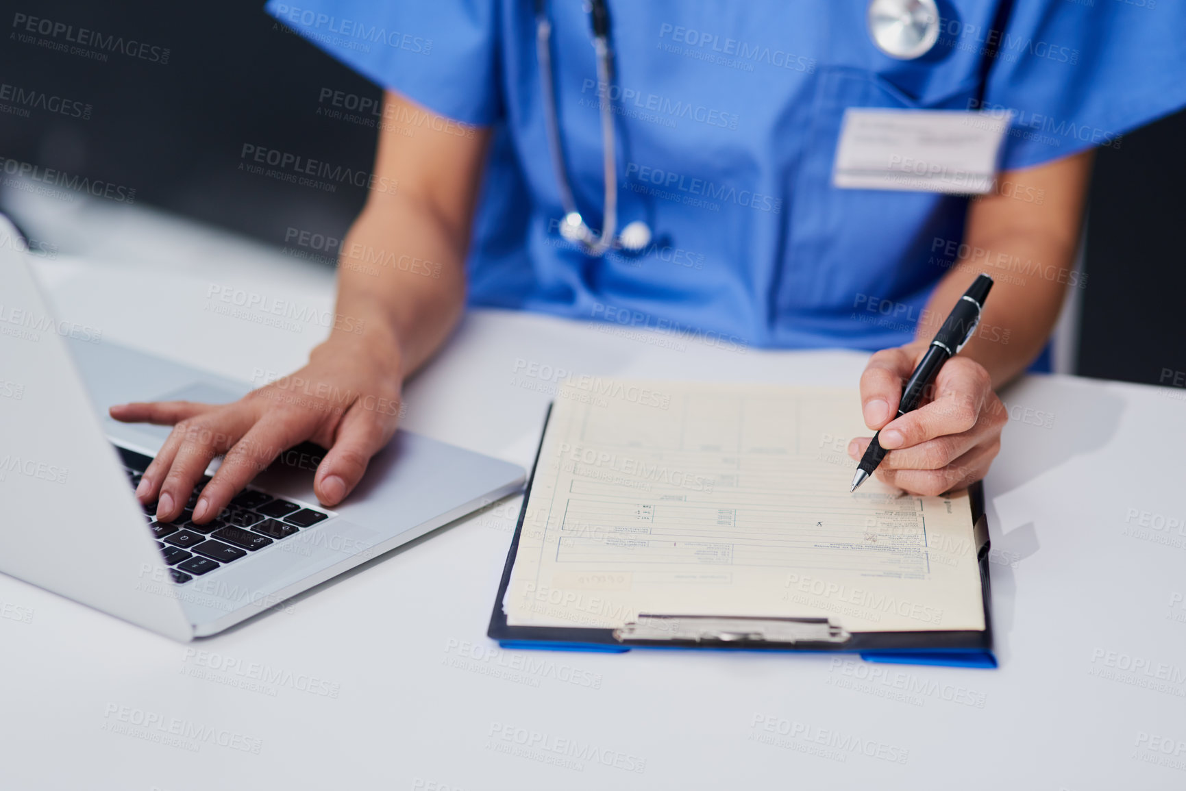 Buy stock photo High angle shot of an unrecognizable female nurse filling out paperwork while sitting at her desk in the hospital
