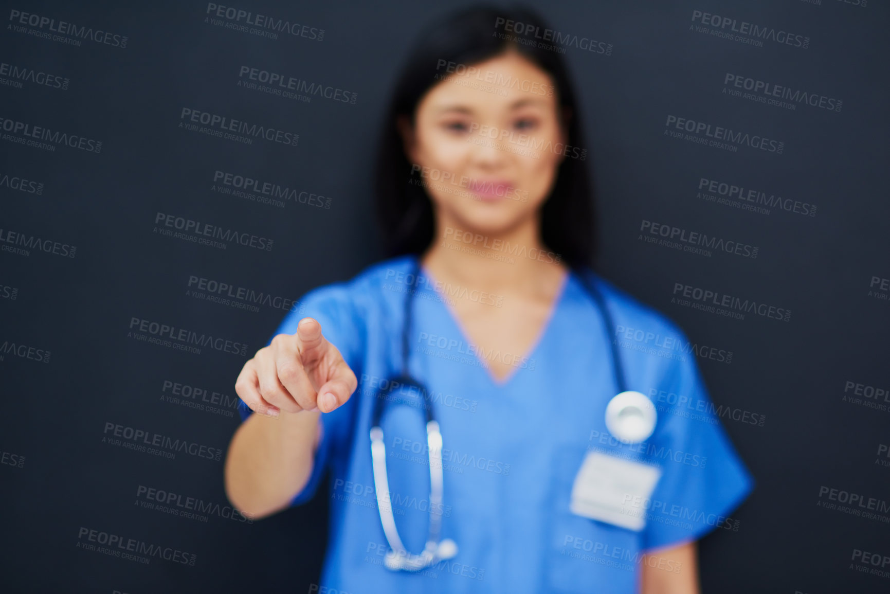 Buy stock photo Cropped portrait of a blurred out female nurse using a touchscreen interface while standing against a black background