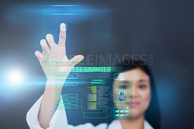 Buy stock photo Cropped shot of an attractive young female nurse using a touchscreen interface while standing against a black background