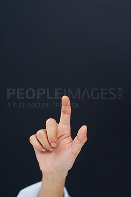 Buy stock photo Cropped shot of an unrecognizable female nurse's hand while using a touchscreen interface while standing against a black background