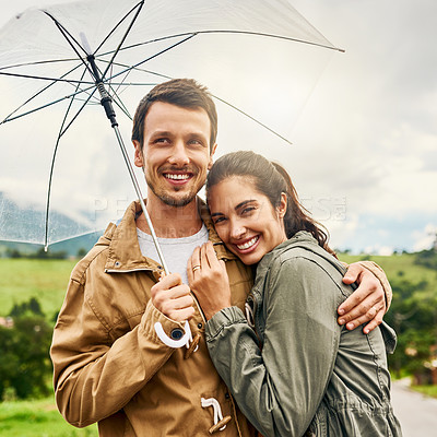Buy stock photo Cropped shot of a loving couple standing outside with an umbrella