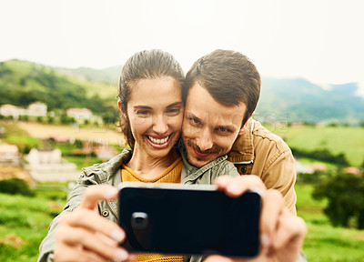 Buy stock photo Cropped shot of a loving couple taking a selfie outdoors