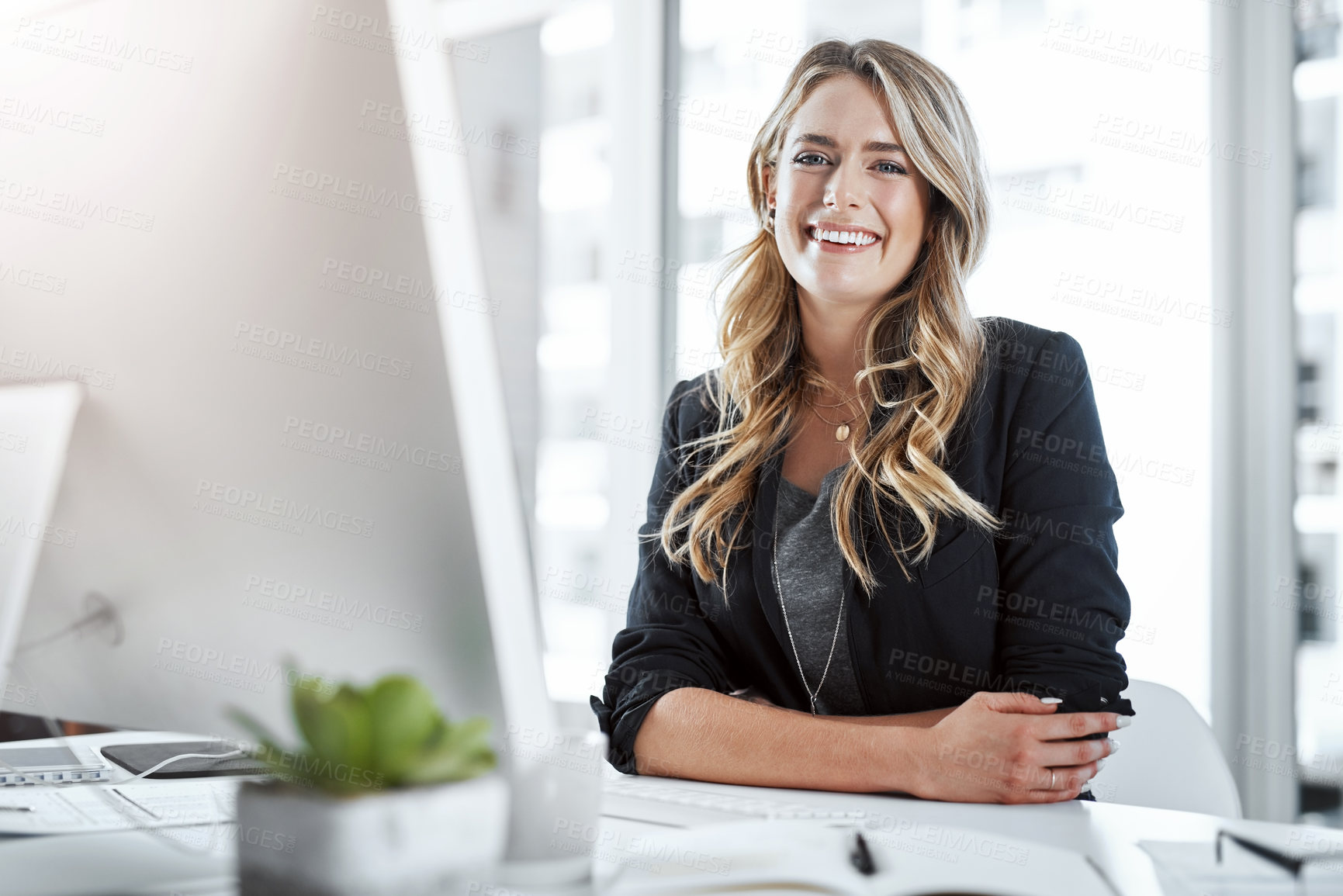 Buy stock photo Portrait of a young businesswoman working at her desk in a modern office