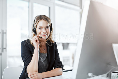 Buy stock photo Portrait of a young woman using a headset and computer at her desk in a modern office
