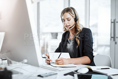 Buy stock photo Woman with headset, call center and writing in notebook, notes and phone call with communication and CRM. Customer service, telemarketing and tech support with female consultant at desk with agenda