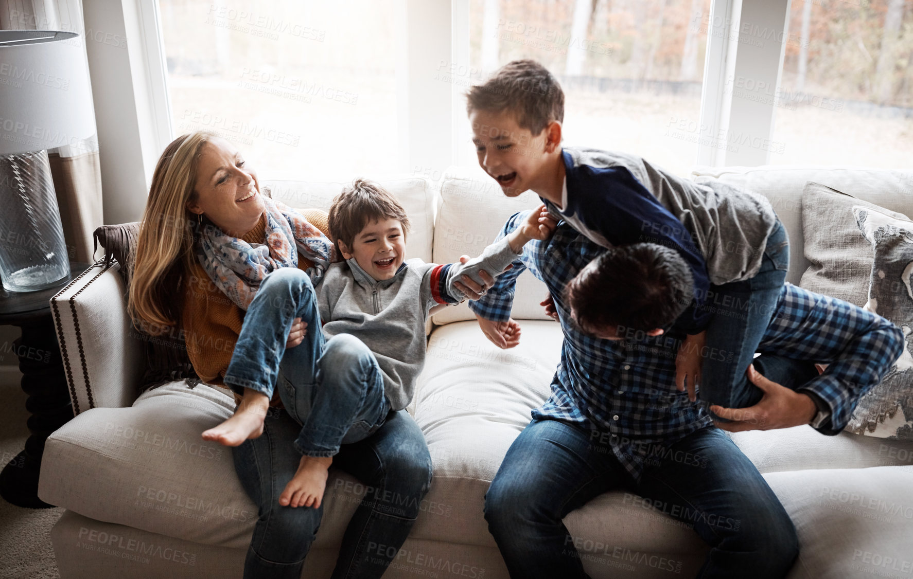 Buy stock photo Parents, children and happy with playing on couch, talk and bonding with love, tickle and piggy back in morning. Mother, father and kids with comic games, care or connection with smile in family home