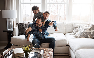 Buy stock photo Father, boy children and playing in living room, fun and carefree with love, energy and happy at family home. Man play with kids on sofa, crazy and playful with piggyback and excited with laughter
