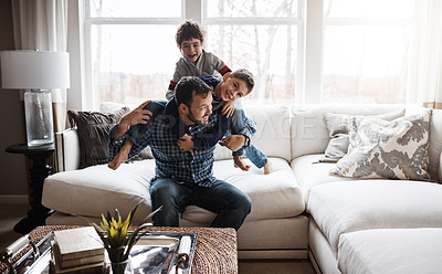Buy stock photo Goofy, funny and bonding father with children on the sofa for playing, quality time and crazy fun. Love, happy and boy kids piling onto dad with energy on the couch of their family home together