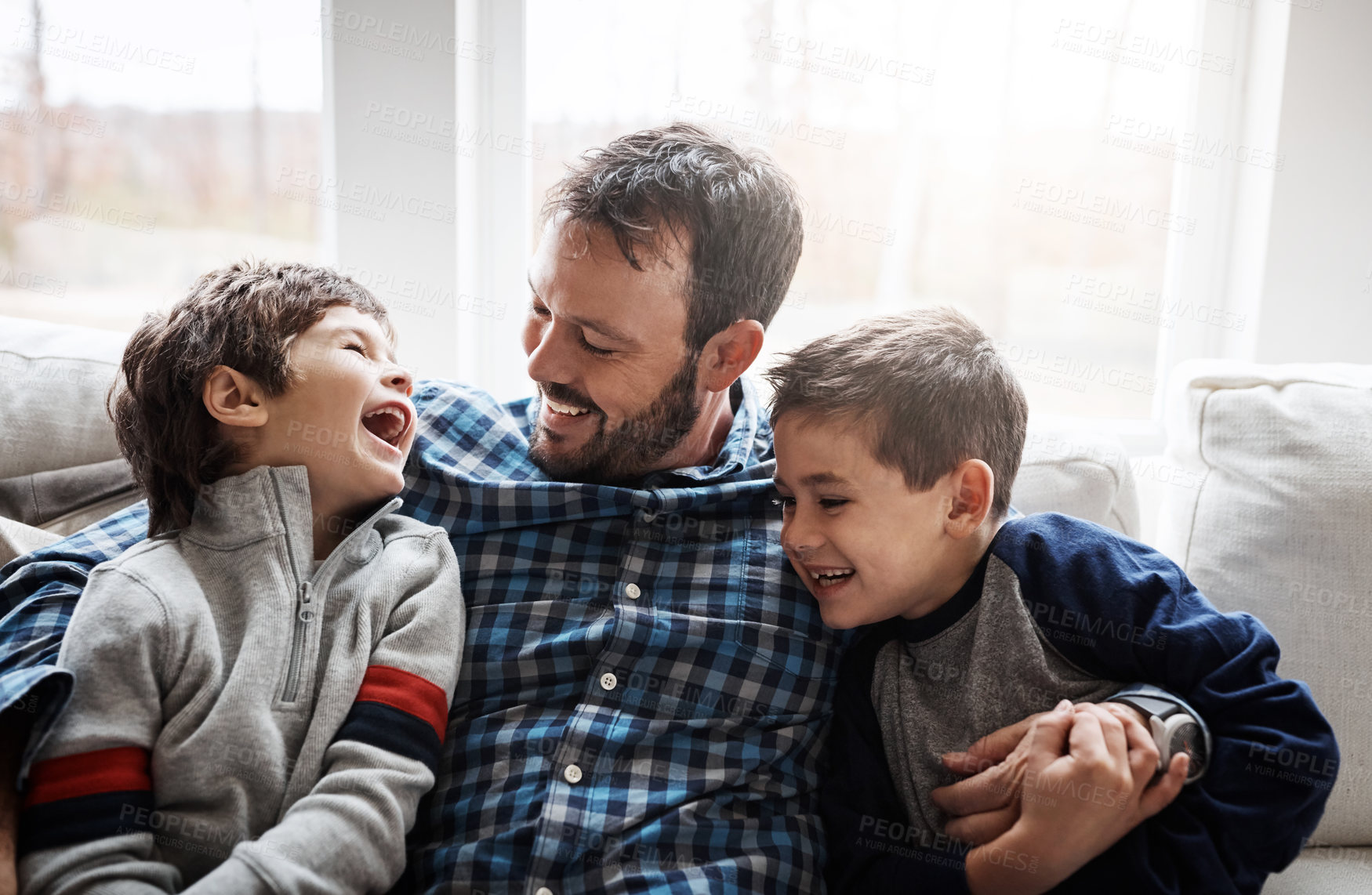 Buy stock photo Laugh, hug and father with children on sofa for bonding, loving relationship and relax together in home. Family, happy and dad with young boys embrace for affection, care and love in living room