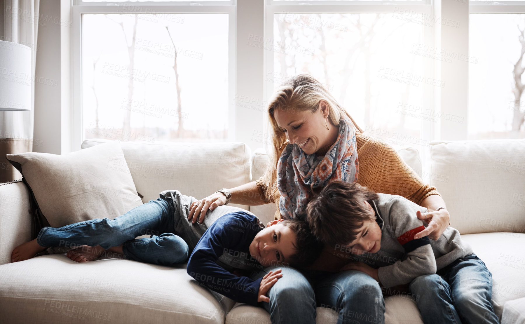 Buy stock photo Happy family, mother bonding with children and relax on sofa   for love, care and smile at home together. People, mom and kids lying on couch in the living room for cozy winter hug or fun with parent