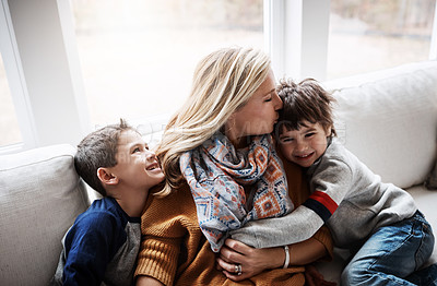 Buy stock photo Happy family, hug and kiss from mother to children while together on living room sofa at the house. Woman and kids in lounge for love, care and safety while bonding to relax and spend time at. home