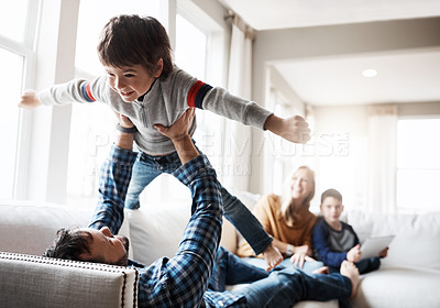 Buy stock photo Wellness, relax and father lifting child on sofa for bonding, fun and play in happy home. Dad playing flying plane in air game with son on living room couch for care, love and bond together