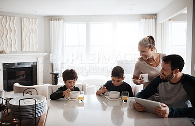 Buy stock photo Shot of two adorable brothers having breakfast together with their parents at home
