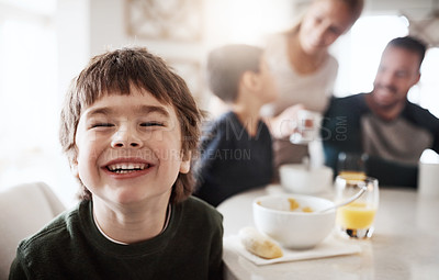 Buy stock photo Portrait of a happy little boy enjoying breakfast together with his family at home