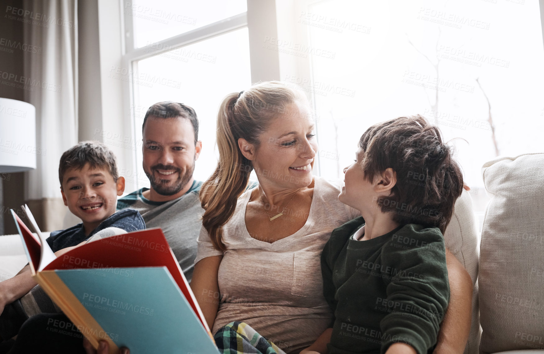 Buy stock photo Love, parents and brothers with a book, sofa and bonding on weekend, loving and learning together. Family, mother and father with boys, child development and reading on couch in living room and relax