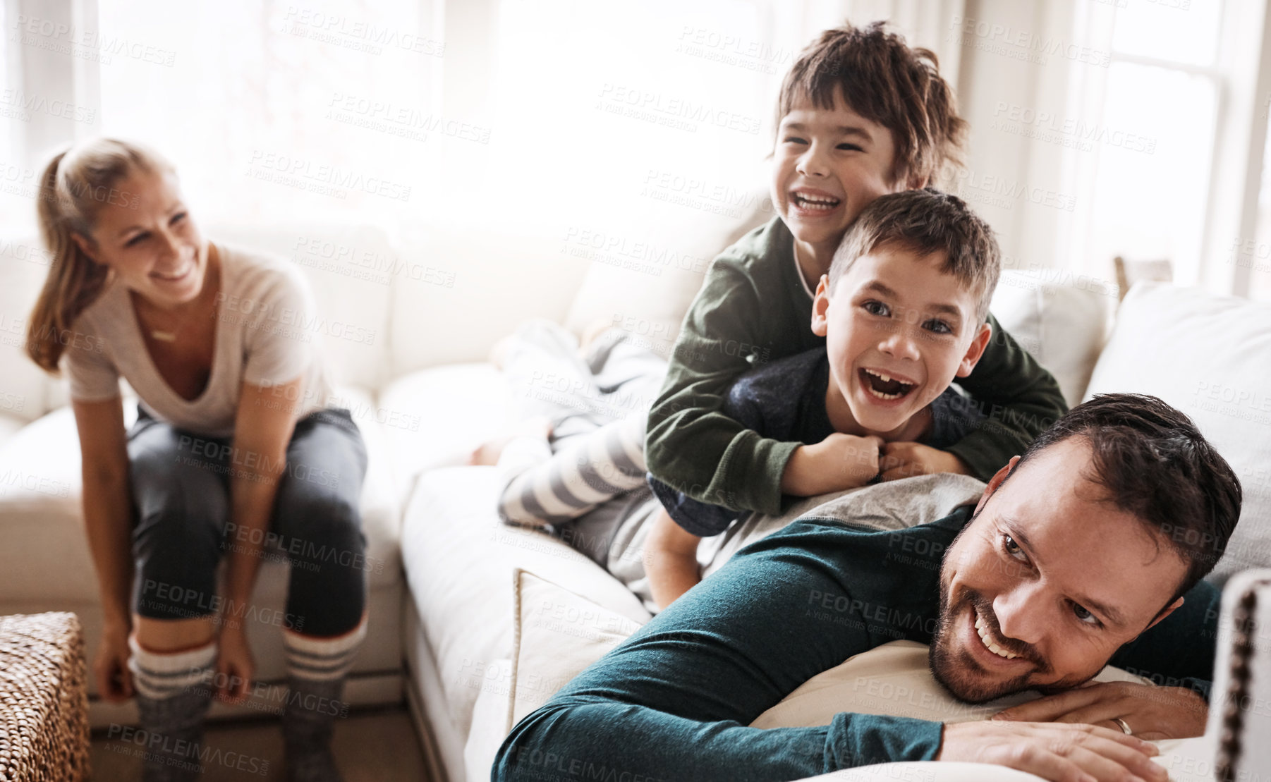 Buy stock photo Happy family, parents and children in a living room at home playing and having fun together in the lounge. Mother, father and kids smiling enjoying and relaxing on the couch or sofa in a house