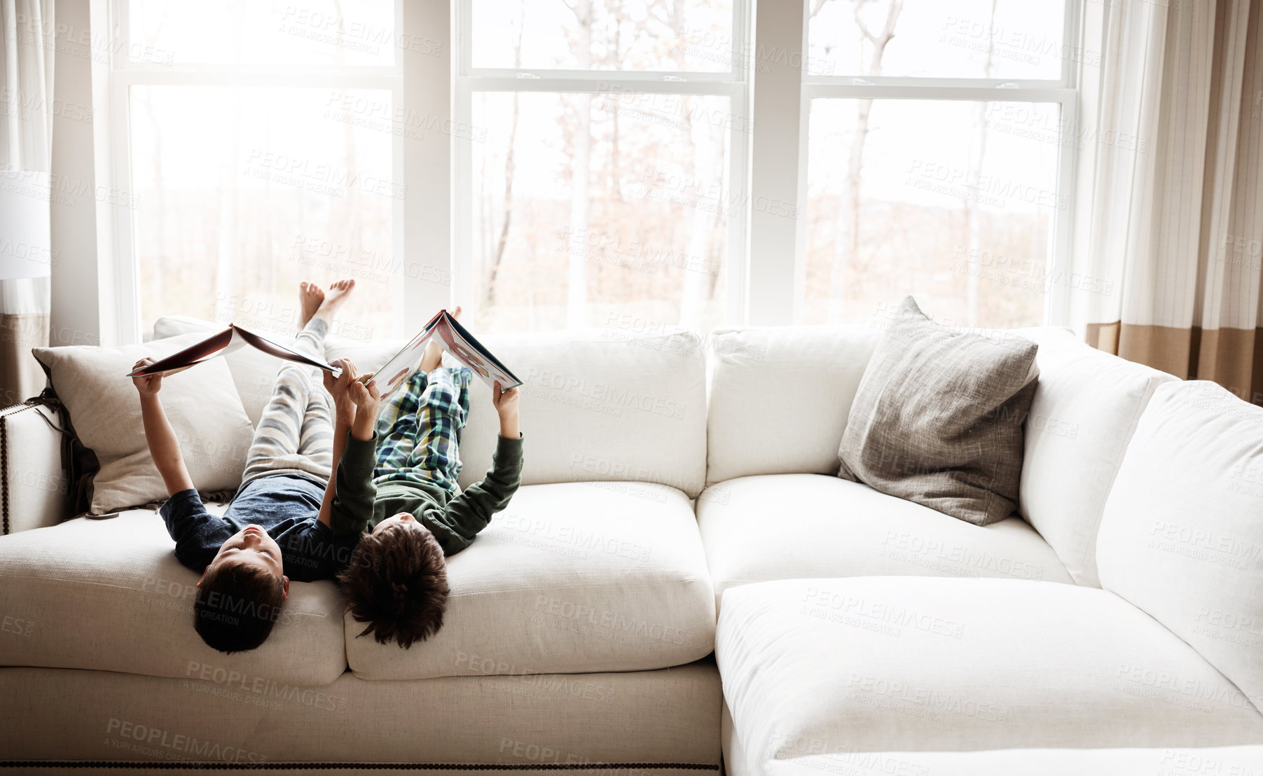 Buy stock photo Fun children, bonding and reading books in education, learning or relax studying upside down on house living room or sofa. kids, storytelling and fantasy fairytale novel in creative home inspiration