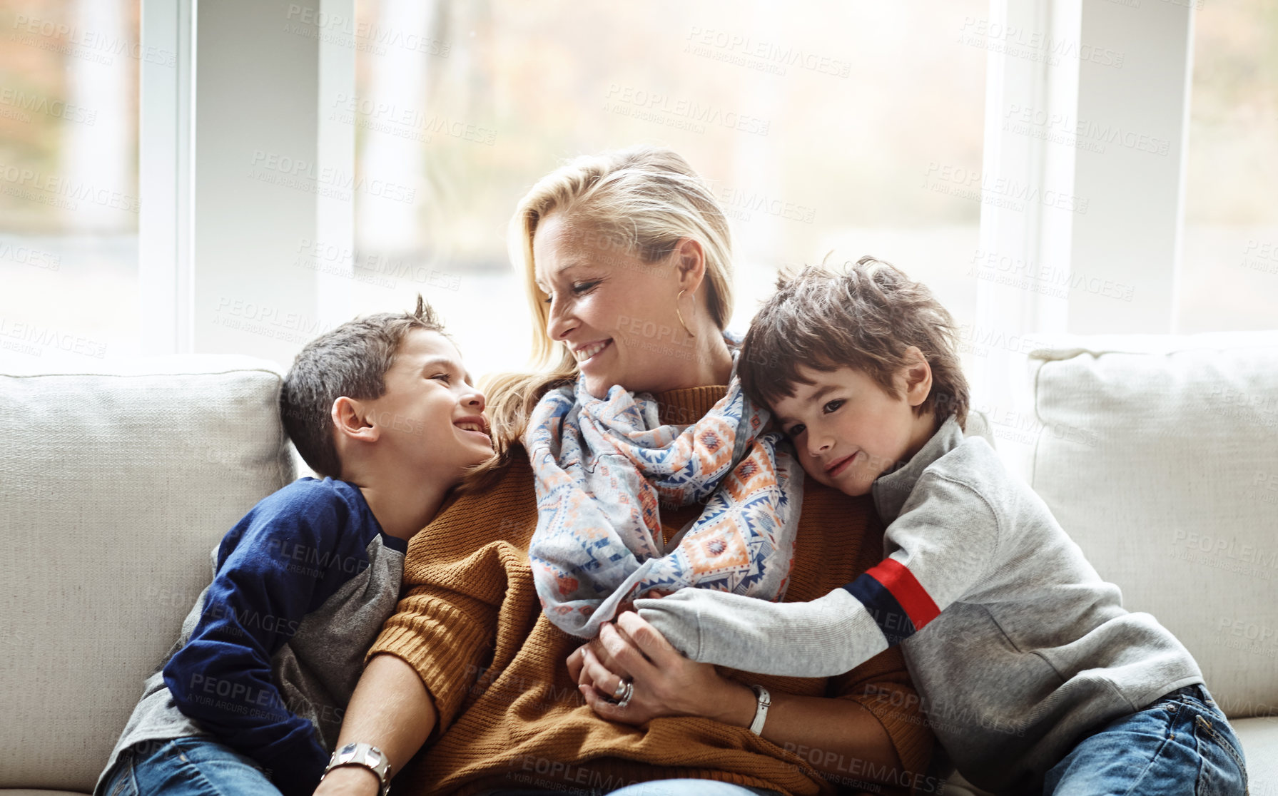 Buy stock photo Shot of two adorable little boys relaxing with their mother on the sofa at home