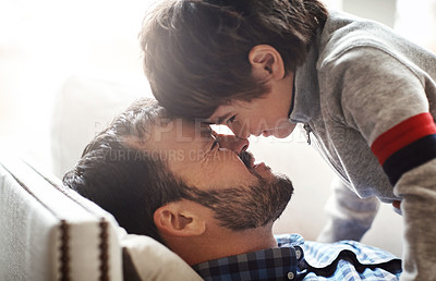 Buy stock photo Father, child and forehead playing on sofa in living room for quality bonding time together at home. Happy dad enjoying holiday, break or play with son relaxing with smile for love and care on couch
