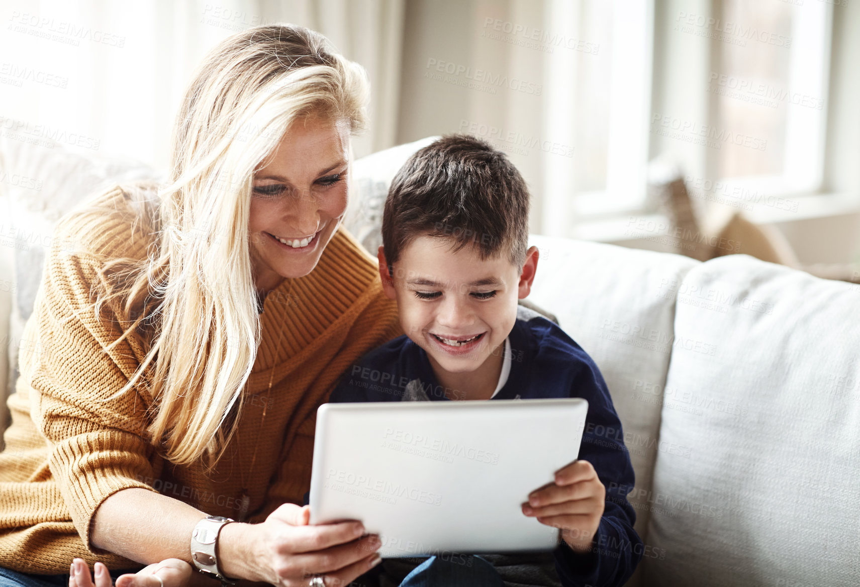 Buy stock photo Happy mother, son and watching with tablet for entertainment, movie or series on living room sofa at home. Mom with child, little boy or kid on technology for fun games, learning or reading at house