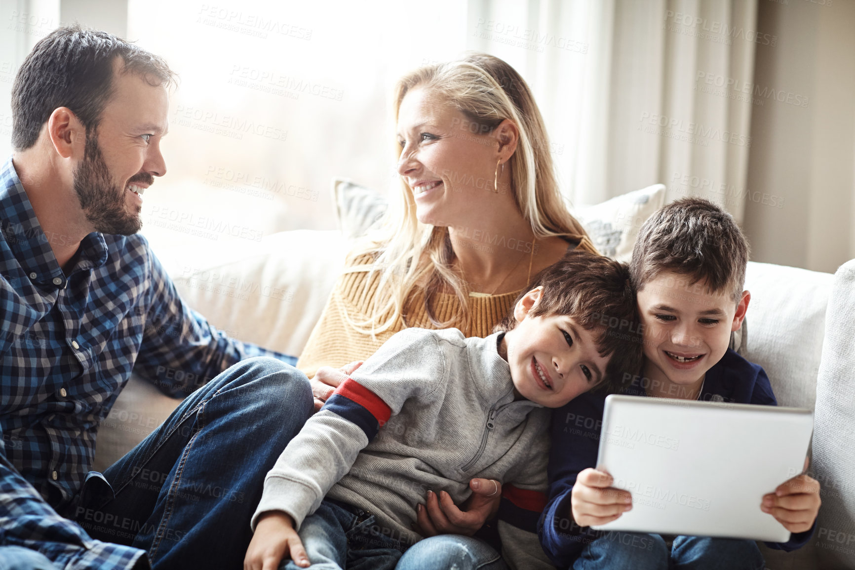 Buy stock photo Tablet, search and kids with parents on a sofa for movies, streaming or gaming, bonding and cartoon in their home together. Happy family, support and people in living room with digital education app