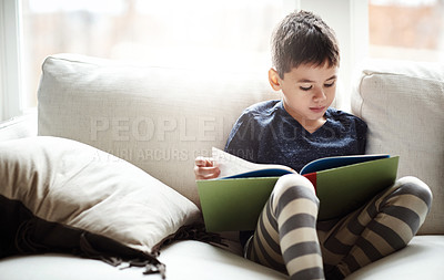 Buy stock photo Boy, sofa and reading with book for story, fairytale or knowledge in literature at home. Male person, child or kid in relax on living room couch with novel for education, fiction or fantasy at house