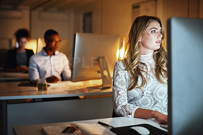 Buy stock photo Shot of a young businesswoman working late on a computer in an office