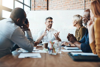 Buy stock photo Shot of a businessman leading a meeting in the boardroom