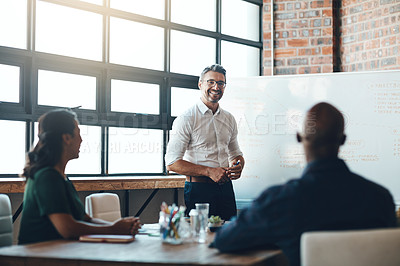 Buy stock photo Shot of a businessman giving a presentation to his colleagues in a boardroom