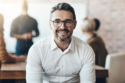 Buy stock photo Leadership, portrait of ceo or businessman smile and sitting in office at work with colleagues behind manager. Entrepreneur or business, leader and smiling male person with glasses sit at workplace 