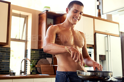 Buy stock photo Cropped shot of a handsome young shirtless man making breakfast in the kitchen at home