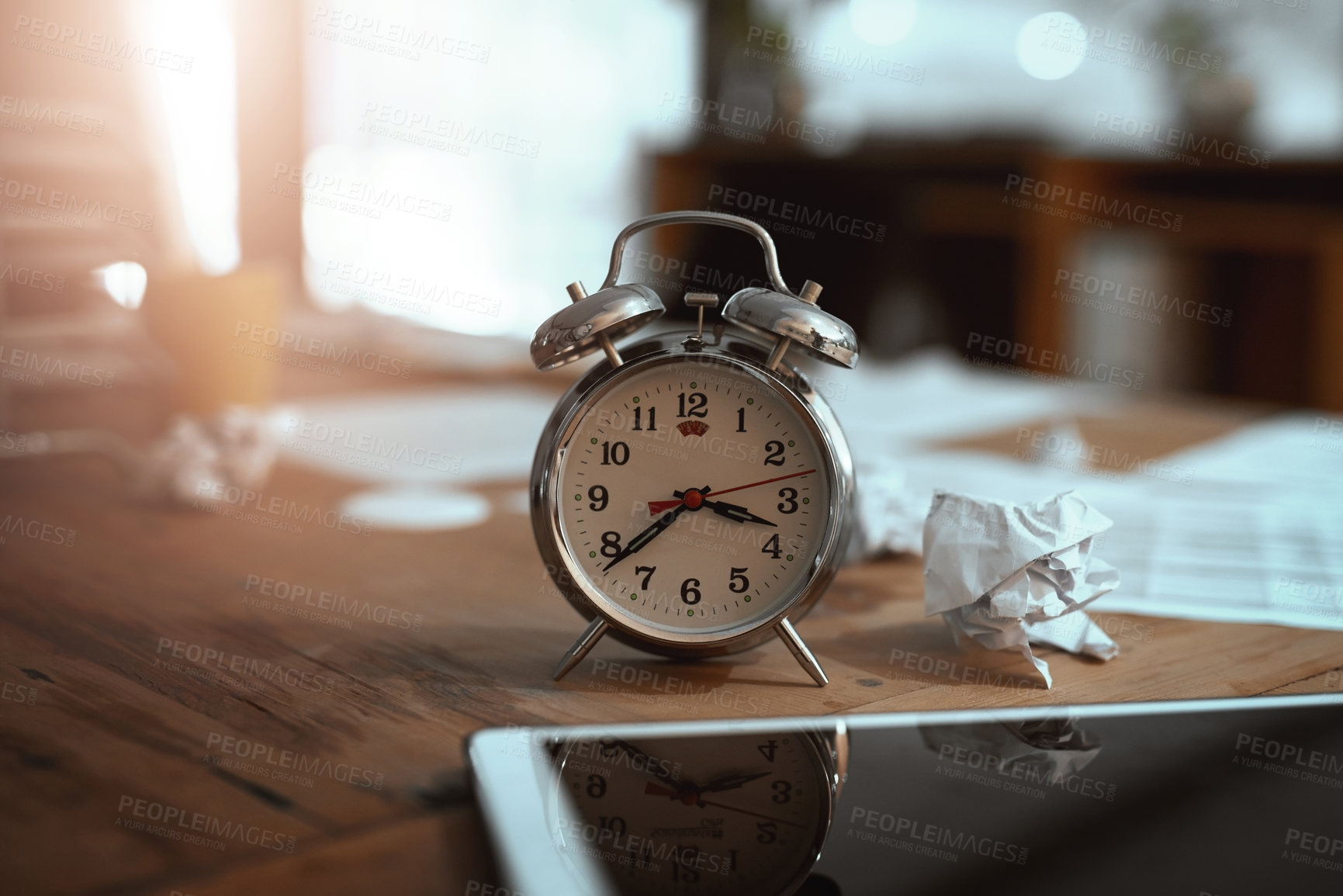 Buy stock photo Still life shot of a clock and crumpled paper on a desk in an office at night